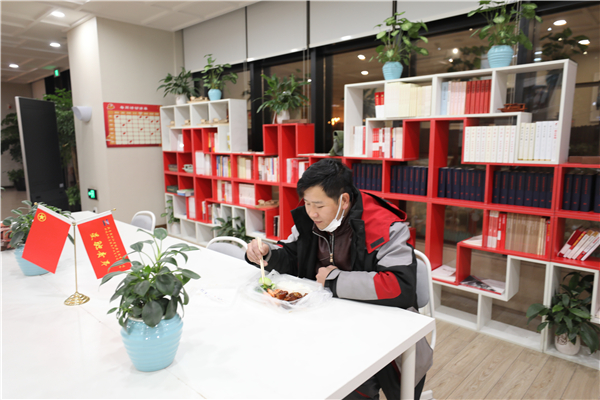 意外滯留在園區(qū)內(nèi)的快遞小哥收到了青年志愿者送來的一份熱騰騰晚餐，讓這個冬雪夜更暖心.jpg